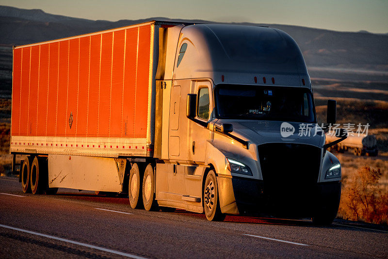 长途半挂卡车在四车道的高速公路上加速运送货物