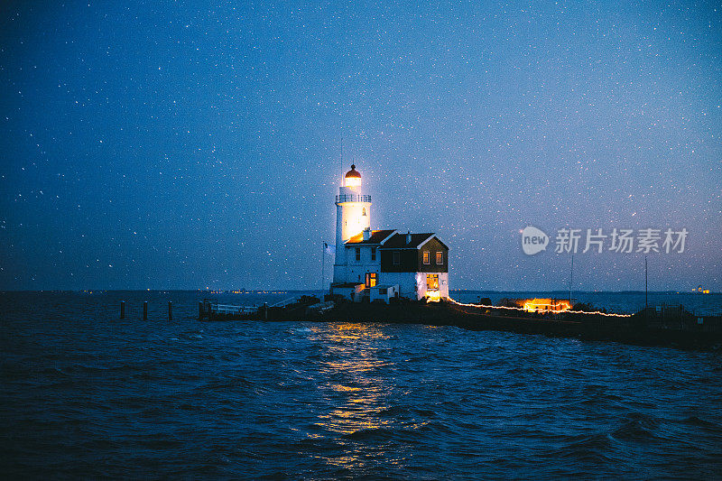 荷兰海岸风景如画的白色灯塔上方的星空