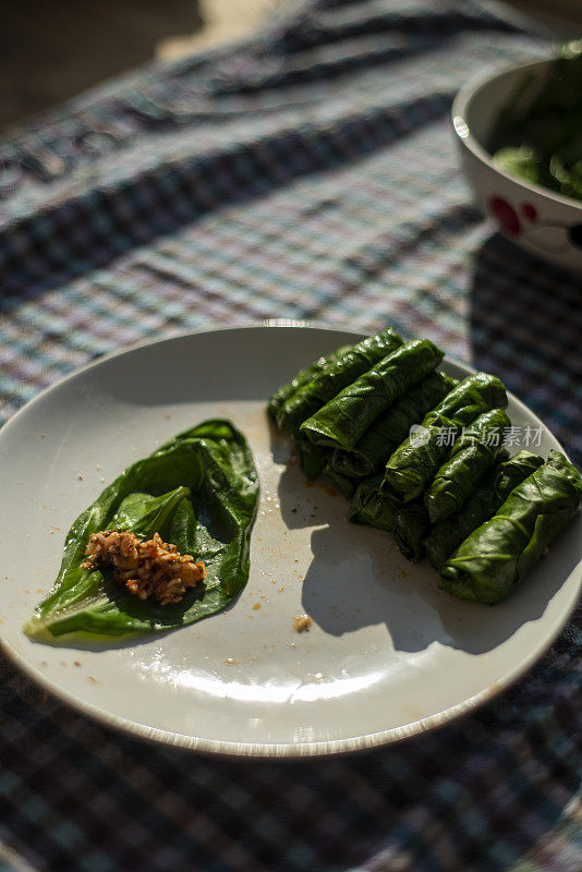 一名妇女正在用菠菜甜菜包米饭做土耳其土豆