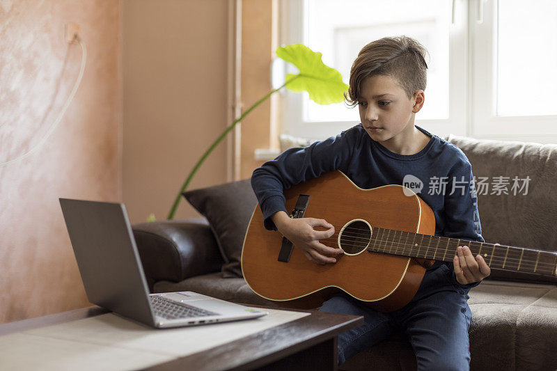 孩子在网络的帮助下学习弹吉他