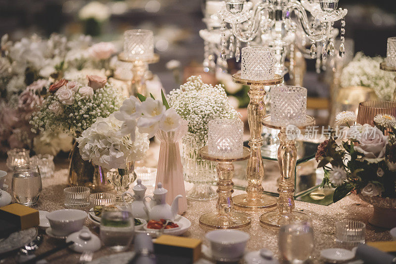 豪华精致的餐桌上装饰着金色主题蜡烛、桌布