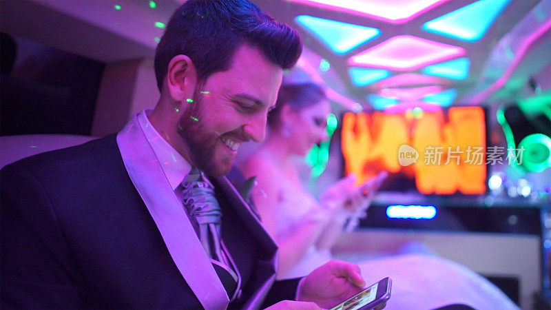 新婚夫妇在去婚礼派对的路上用智能手机