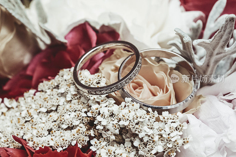 一对结婚戒指放在婚礼花束上