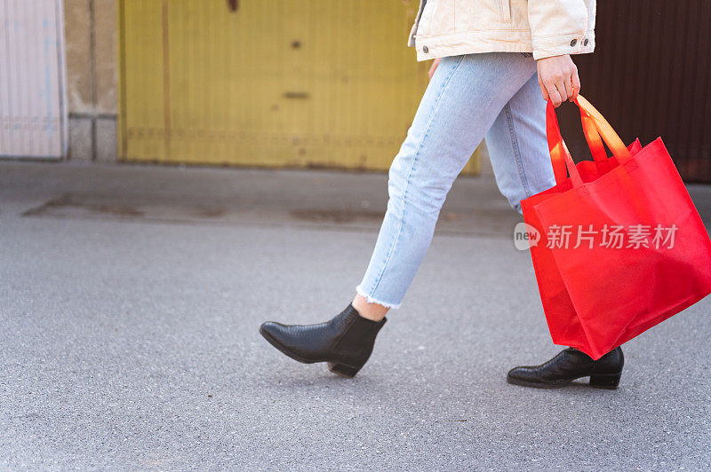 低段女人走在红色购物袋户外车库库存照片