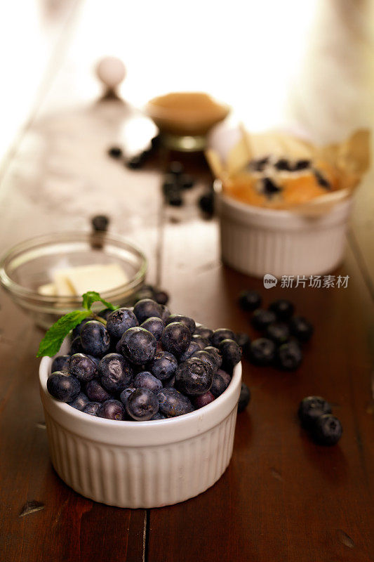 新鲜蓝莓和烤蓝莓松饼放在木桌上
