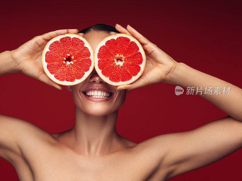 一个女孩拿着红葡萄柚的肖像