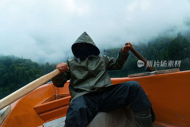 人在湖上钓鱼，从船雨衣船神秘危险