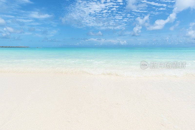 热带海滩和碧绿的海浪与晴朗的天空背景