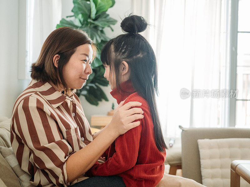 亚裔母亲和她的女儿在客厅玩。