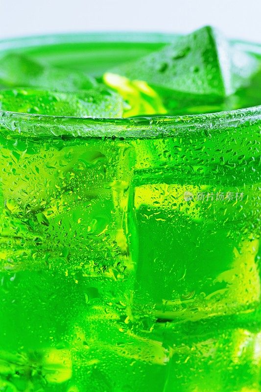 一杯加冰块的绿色冷饮。