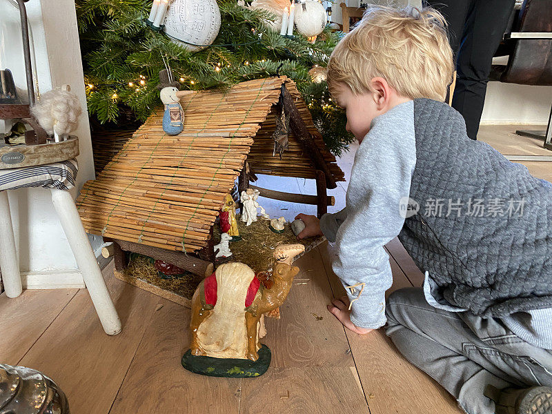 孩子们正在装饰耶稣诞生的场景