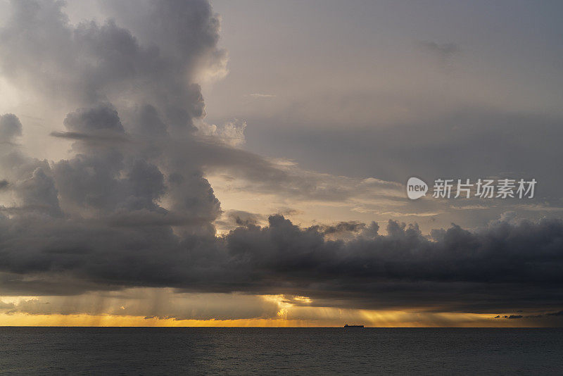 在斯里兰卡的希卡杜瓦，印度洋上空的壮观的天空和大量的雨云在风景优美的日落上。