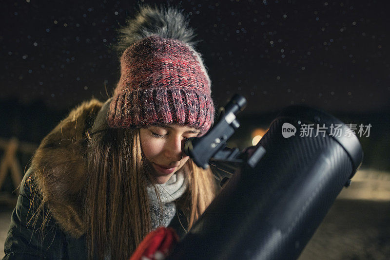 少女用望远镜观测冬夜的天空