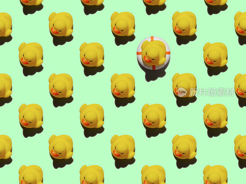 许多黄色橡皮鸭以抽象的形式重复图案，一只黄色橡皮鸭坐在一个充气救生圈上，以绿松石为背景，从人群中脱颖而出。