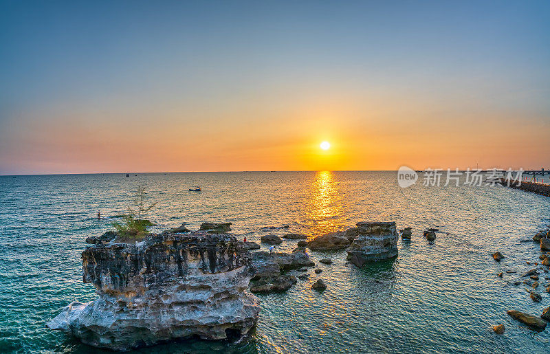 在越南富国珍珠岛面向大海的抽象石灰岩海滩上的日落