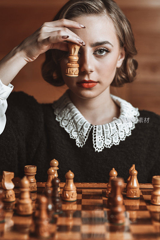 女性用棋子遮住眼睛，思考下一步行动