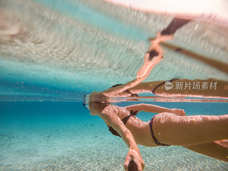 年轻女子在清澈湛蓝的大海下自拍