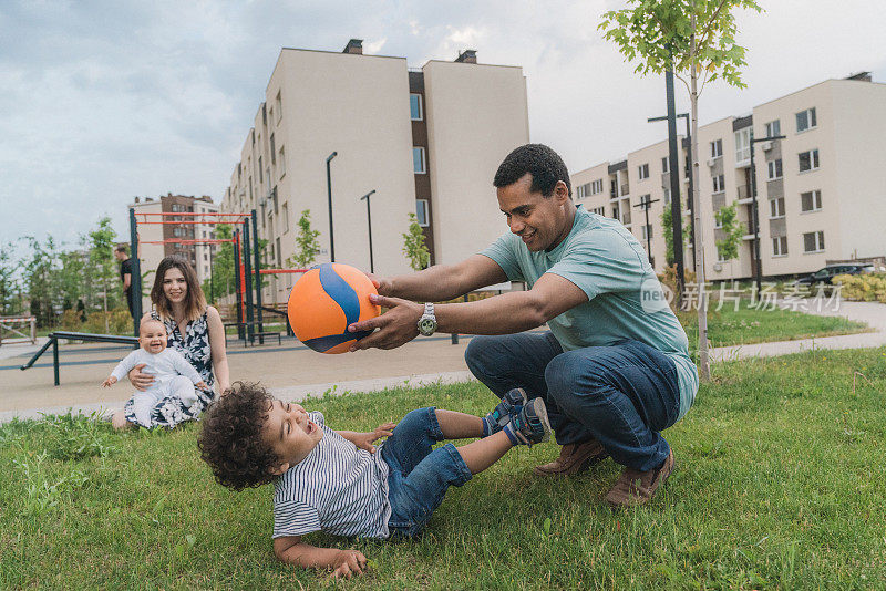 混血儿家庭，两个孩子在外面玩球在夏天