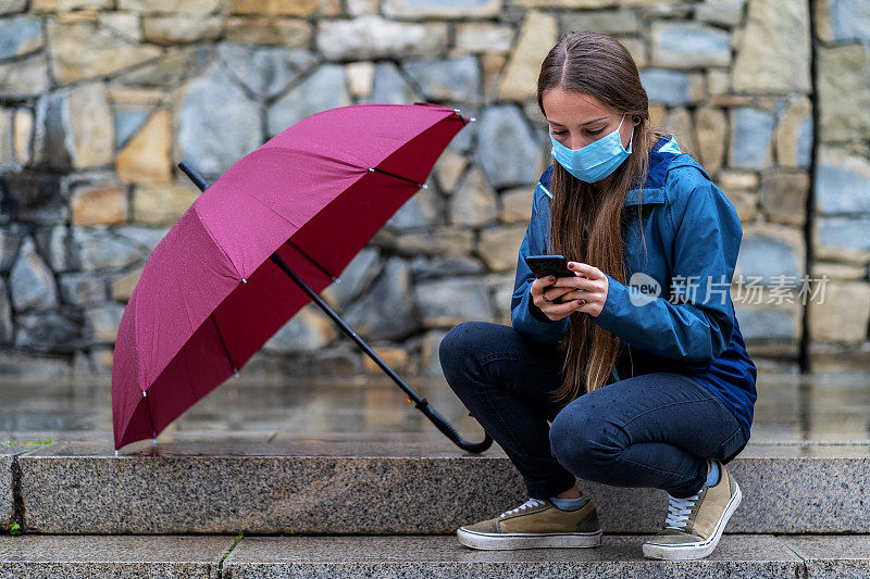 一个悲伤的少女在雨天的楼梯上