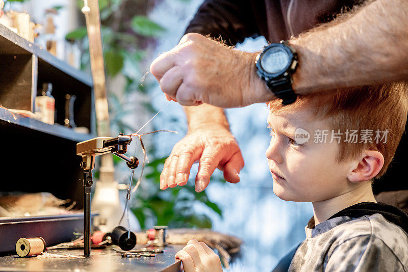 爷爷在家教他的孙子如何让钓鱼飞蝇