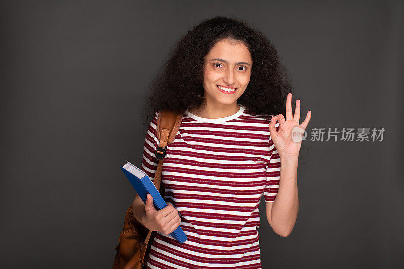 年轻女孩学生的肖像持有笔记本和有背包库存的图像