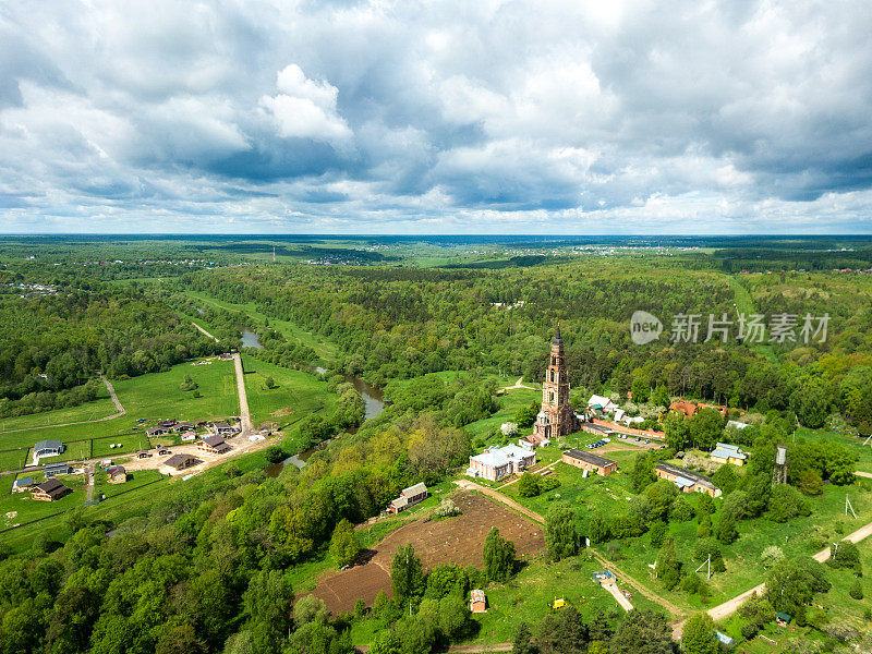 夏天的国家风景。重建时的小村落和旧钟楼鸟瞰图