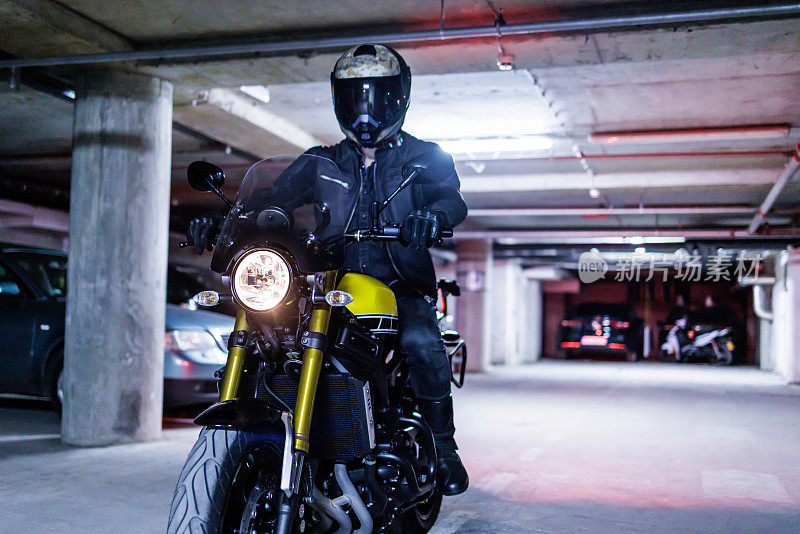 摩托车手晚上在车库里骑摩托车