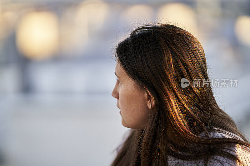 侧面拍摄的黑发的青春期前女孩盯着她前面的东西