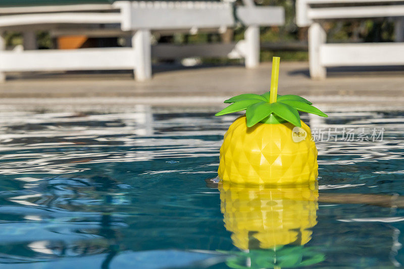 菠萝形状的鸡尾酒杯在游泳池游泳