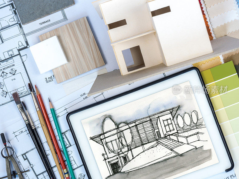 建筑师，室内设计师工作台与家庭模型，草图和平板电脑