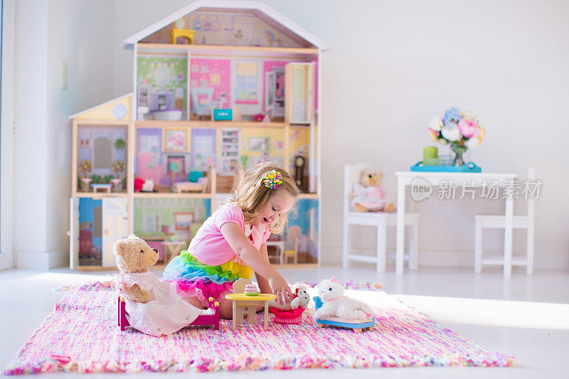 小女孩玩毛绒玩具和玩具屋