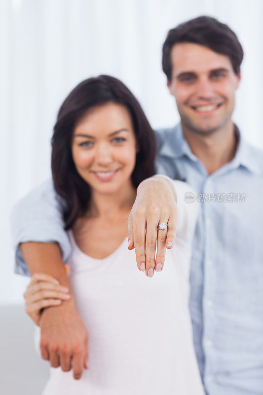 一个女人在镜头前展示她的订婚戒指