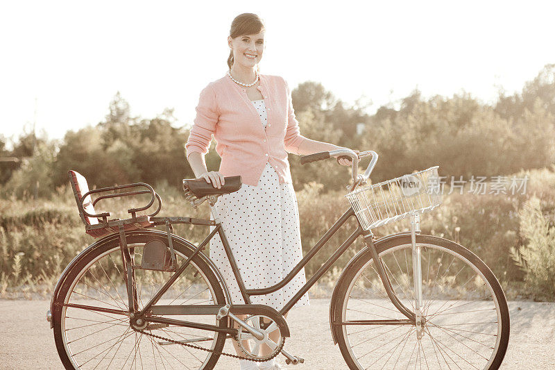 快乐，复古的年轻女人站在复古自行车