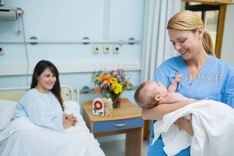 微笑的护士抱着新生婴儿