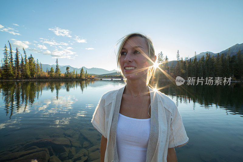 日落时分湖边一位年轻女子的肖像。