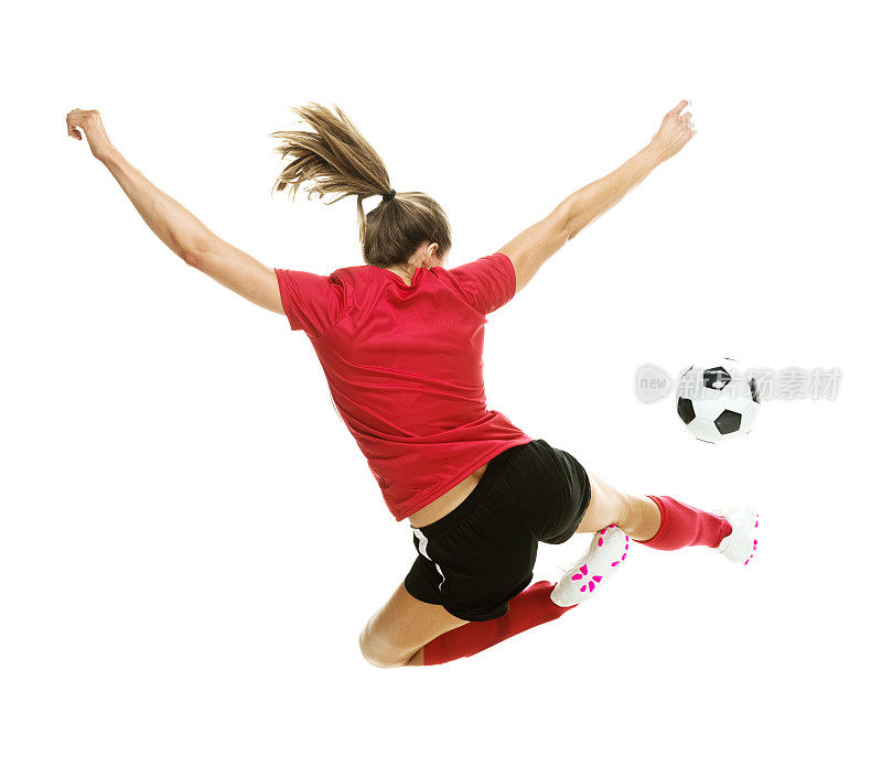女足球运动员踢足球的后视图