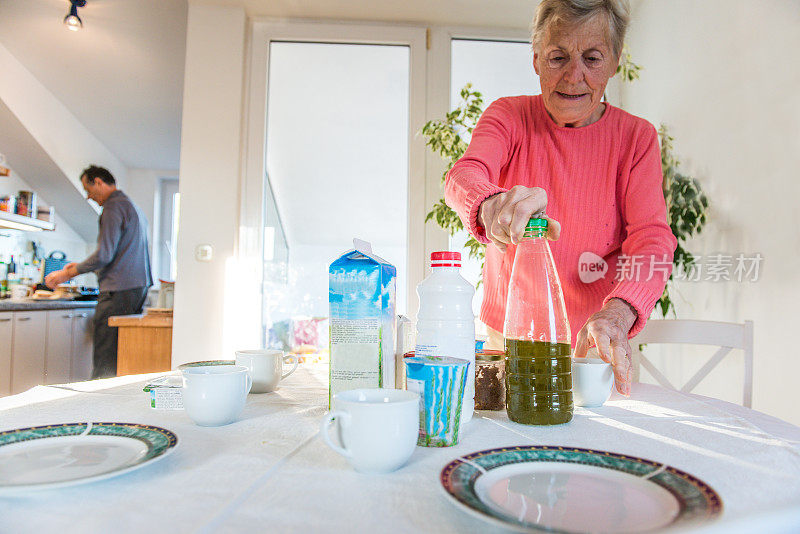 克罗地亚布拉克，穿着睡衣准备早餐的资深白人夫妇