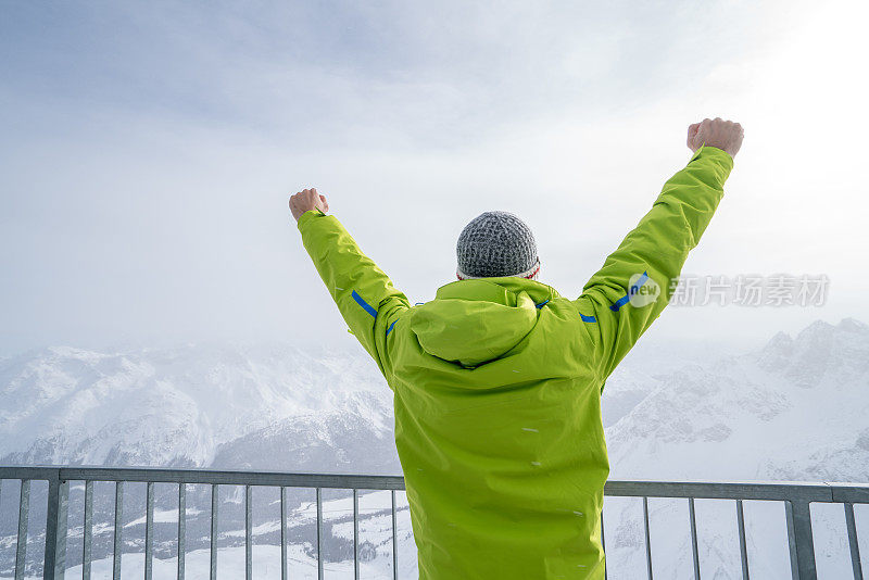 一个年轻人在滑雪坡上伸开双臂