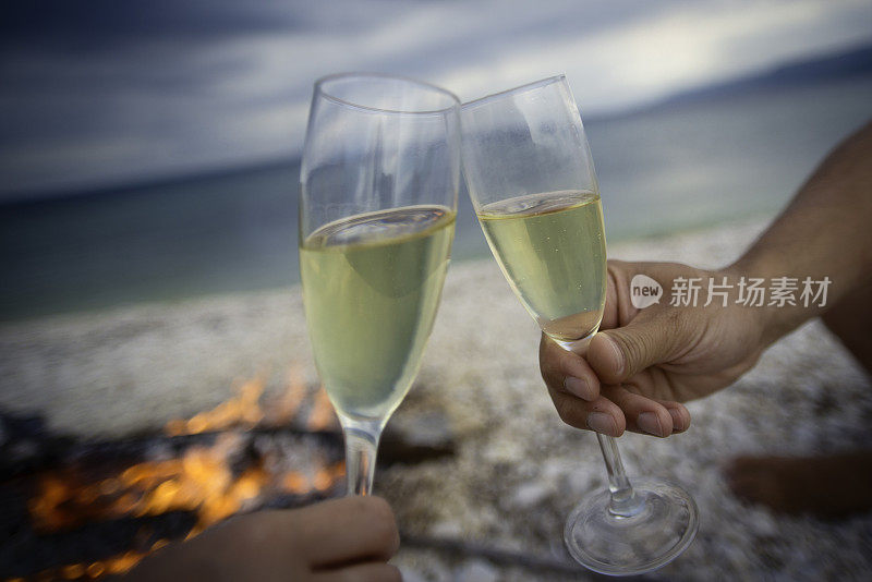 一对夫妇在海滩上用香槟祝酒