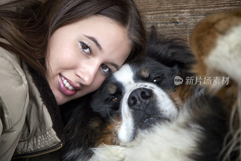 微笑美丽的年轻女人与伯恩山狗，特写