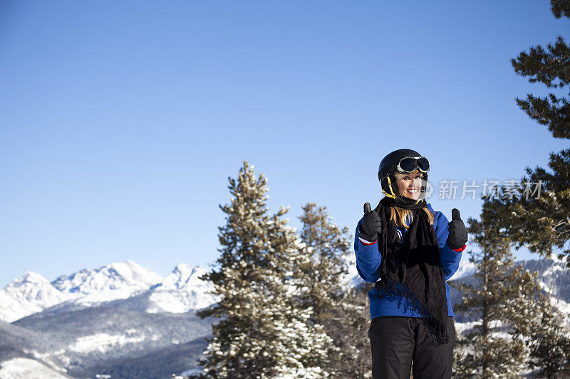 在山顶滑雪坡道上的女滑雪者。