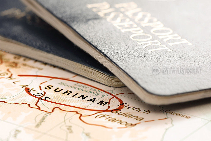 目的地苏里南。地图上的护照。旅行的概念。