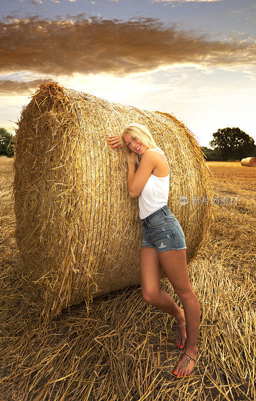 金发女孩躺在稻草捆上休息