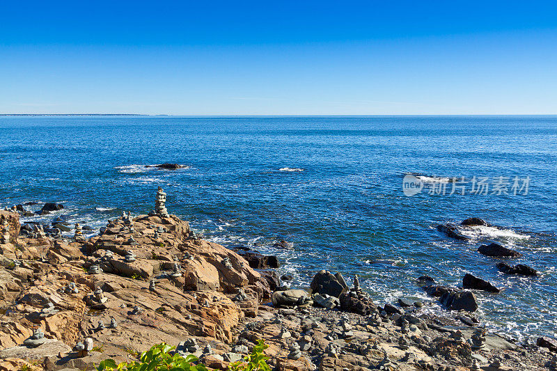 缅因州Ogunquit的岩石和海洋冲浪。蓝色的天空。