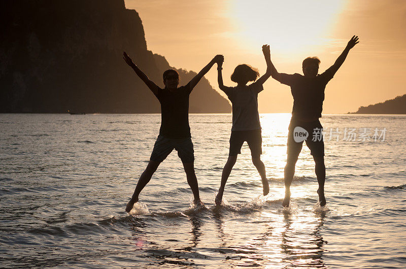 幸福的一家人在海滩上散步