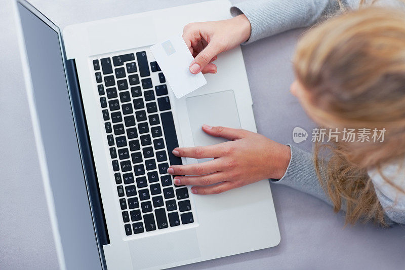 女人用笔记本电脑和信用卡在网上购物