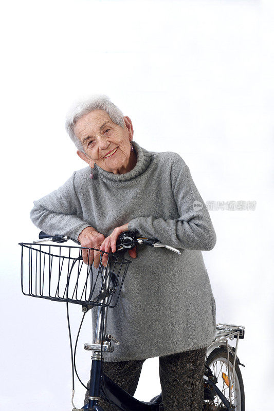 老妇人骑着自行车孤立在白色背景上