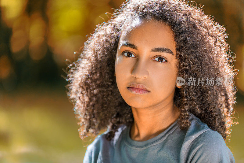 美丽的混血儿非裔美国女孩十几岁的女性年轻的女人在秋天或秋天看起来悲伤沮丧或体贴
