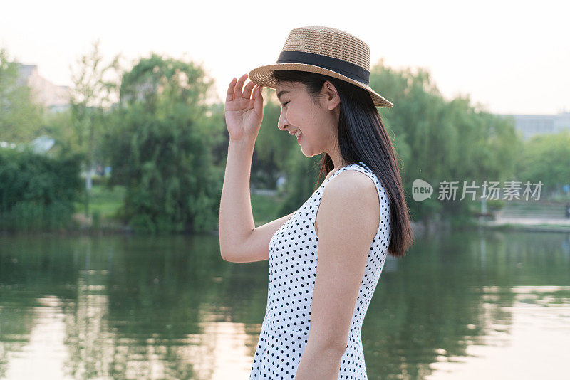 一个快乐的女人站在湖边的肖像