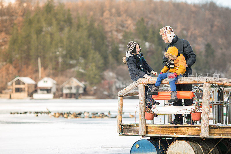 父亲和儿子们冬天在湖里玩